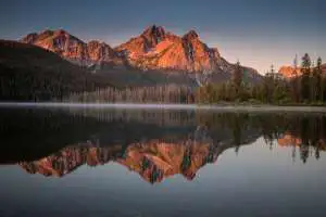 brown mountain near body of water during daytime